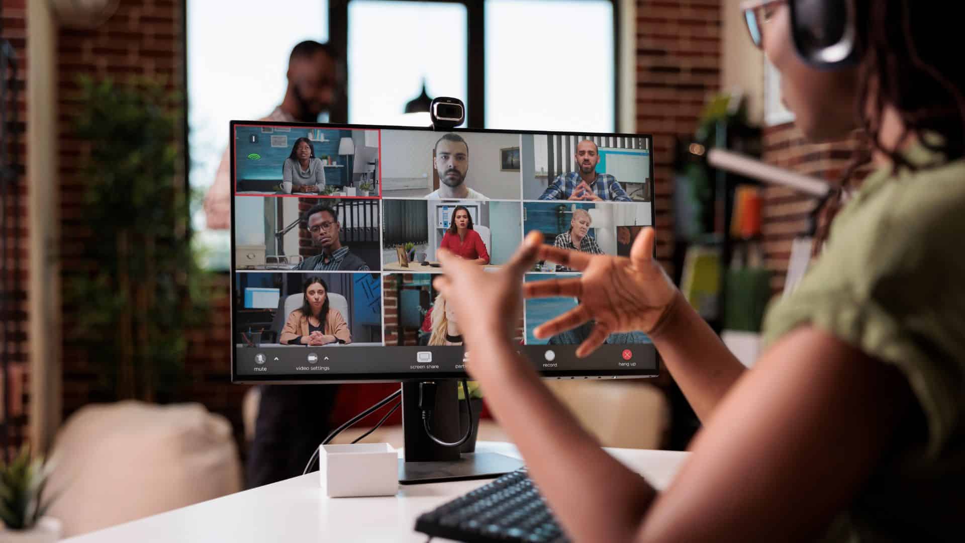 startup employee working from home gesturing in video conference with colleagues 1